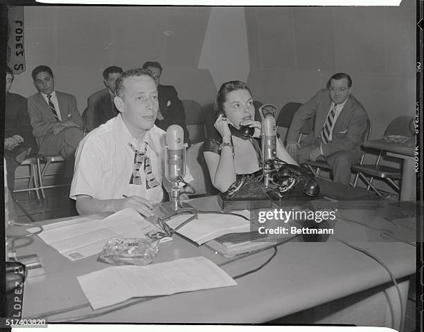 Motion picture star Judy Garland answers the phone here, while on a visit to disc jockey Jack Eigen, . She took part in the radio program, during her...