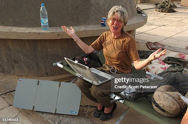 Anne Garrels, correspondent for National Public Radio, gestures as she works on a story on the roof of a U.S. Marine base November 14, 2004 in...