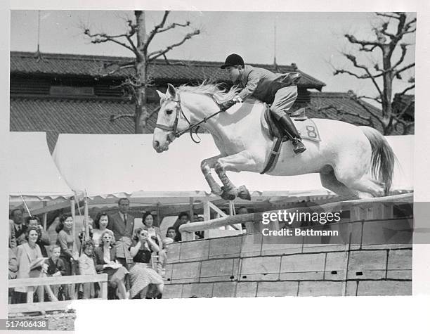 Royal Horsemanship. Tokyo, Japan: Eighteen-year-old Crown Prince Akihito of Japan takes a hurdle in fine style in one of the many jumps that won him...