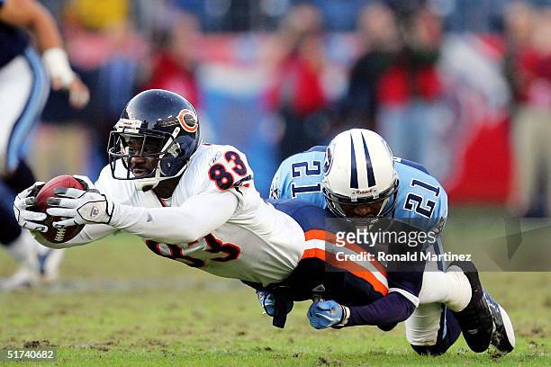 Wide receiver David Terrell of the Chicago Bears stretches for the first down while tackled by Samari Rolle of the Tennessee Titans on November 14,...
