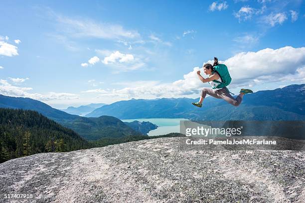 mujer joven deportiva con mochila salto en desierto cima de la montaña, canadá - media summit fotografías e imágenes de stock