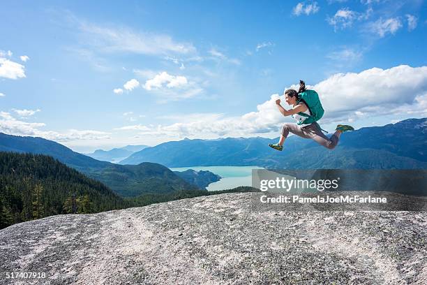 young woman hiker with backpack jumping on wilderness mountaintop, canada - teenager awe stock pictures, royalty-free photos & images