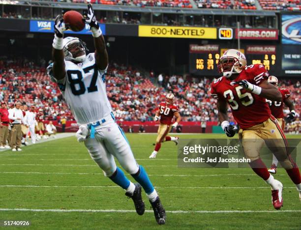 Muhsin Muhammad of the Carolina Panthers catches a touchdown pass to make the score 37-27 against Dwaine Carpenter of the San Francisco 49ers at...