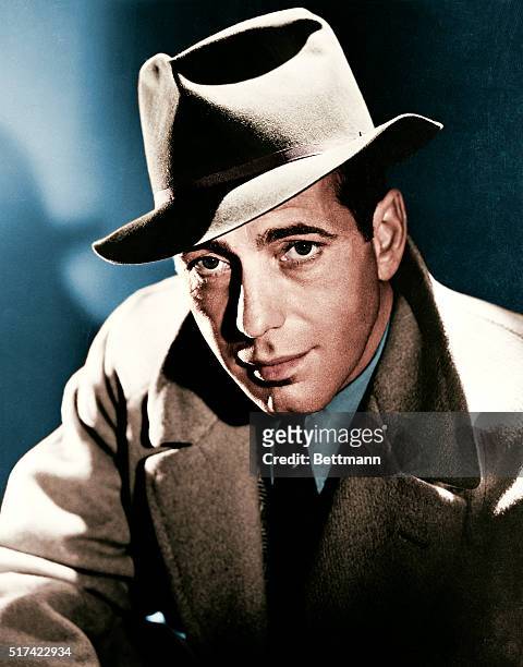 Actor Humphrey Bogart wearing a fedora hat and overcoat.