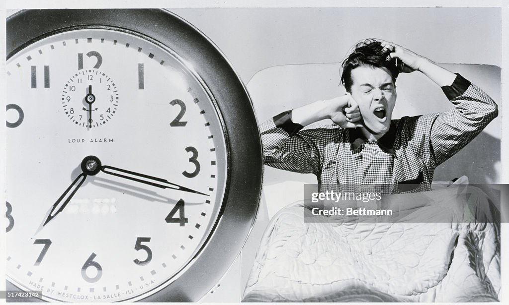 Man Waking Up To Alarm Clock