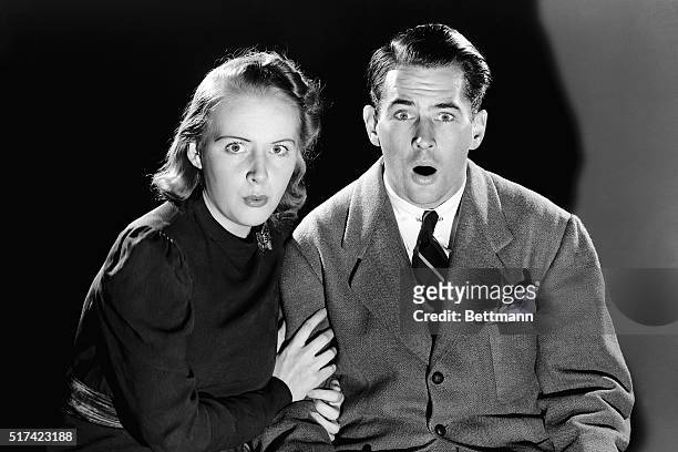 Mary Rumsey and E. Cutrer, Jr., demonstrate startled expressions as they pose in a darkened room. Ca. 1950-1960.