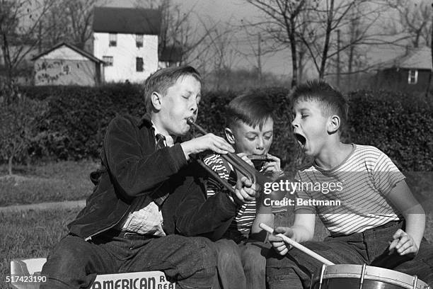 Dick Burkert, Stan Edwards, and Abe Leidtka in "Juvenile Harmony". Photo shows three young boys playing musical instruments: trumpet, harmonica and...