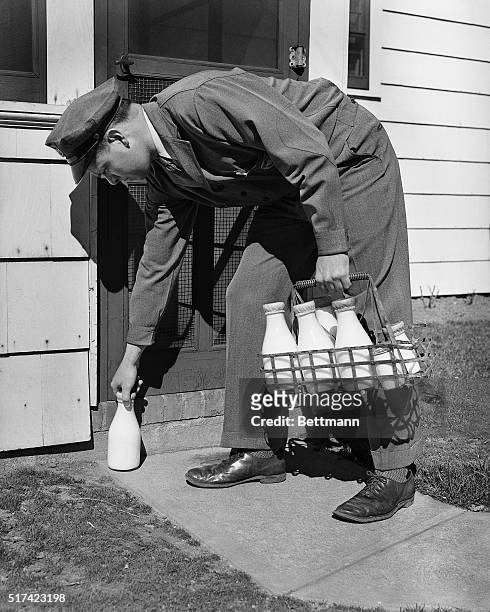 The milkman leaving milk on the doorstep. Model: W.T. Donnelly. Undated photograph.
