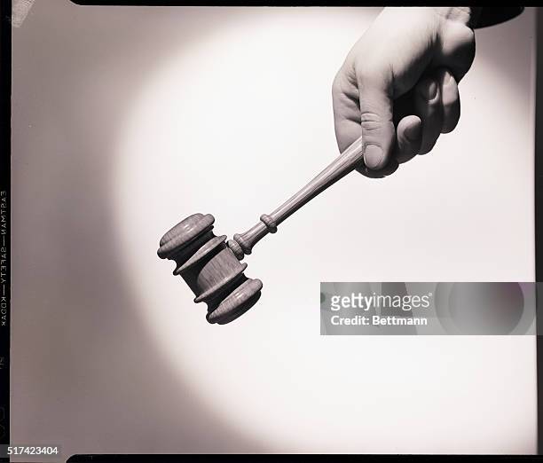 Photo shows a man's hand holding a gavel. Undated.
