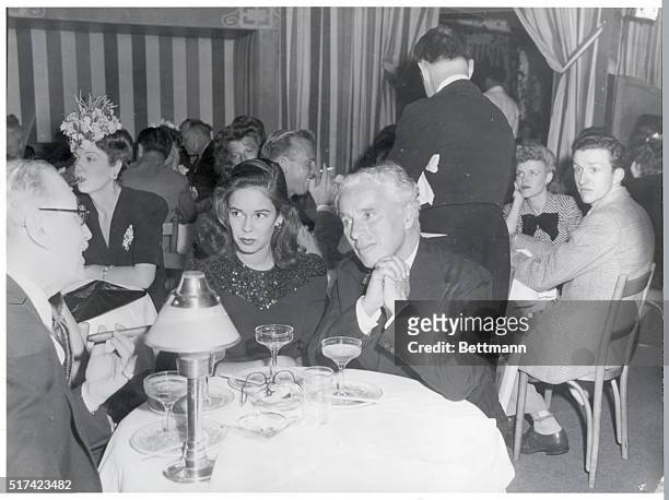 Comedic actor Charlie Chaplin and wife, Oona O'Neill are shown seated at a table at Club Mocambo.