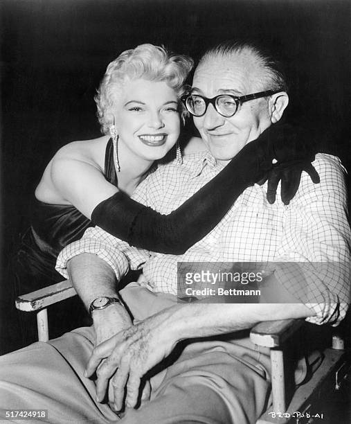 Blonde, curvesome Barbara Nichols "red-apples" her boss, noted director Fritz Lang, on the set of RKO's Beyond a Reasonable Doubt, a Bert Friedlob...