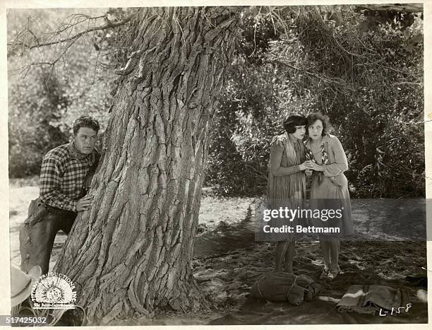 Jobyna Ralston and Margaret Livingston cling to each other as Guinn 'Big Boy' Williams hides behind a tree in Lightening, a black and white silent...