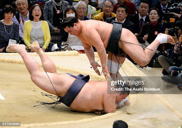 Mongolian yokozuna Harumafuji throws ozeki Kisenosato to win during day twelve of the Grand Sumo Spring Tournament at the Edion Arena Osaka on March...