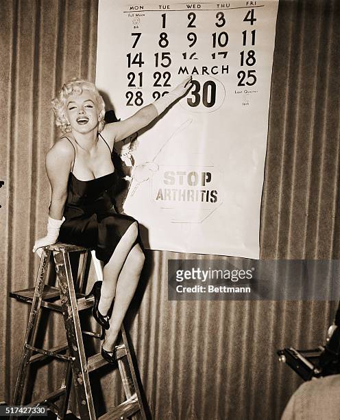 Actress Marilyn Monroe points to the encircled date, March 30th, the day she'll ride an elephant, a pink one, for the sake of charity on the New York...