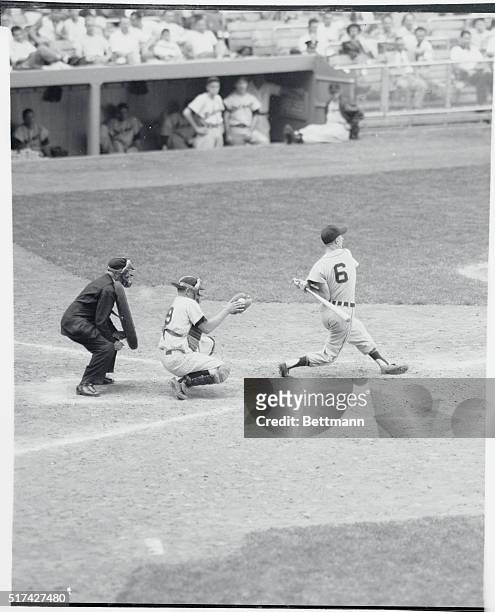 Outfielder Al Kaline, Detroit Tigers, swinging his bat, with catcher Silvera, Yankees and Umpire Grieve.