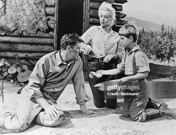 Marilyn Monroe, Robert Mitchum, and Tommy Retting as Matt Calder, Kay Weston, and Mark Calder, in River of No Return.