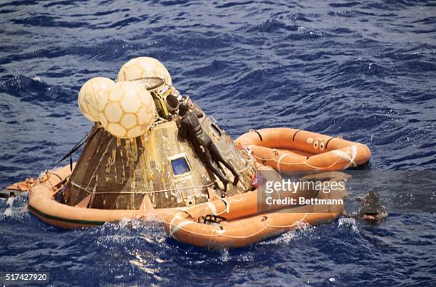 In the Pacific Ocean: After attaching flotation collar around capsule, U.S. Navy frogmen get set to help Apollo 12 astronauts Charles Conrad, Alan...