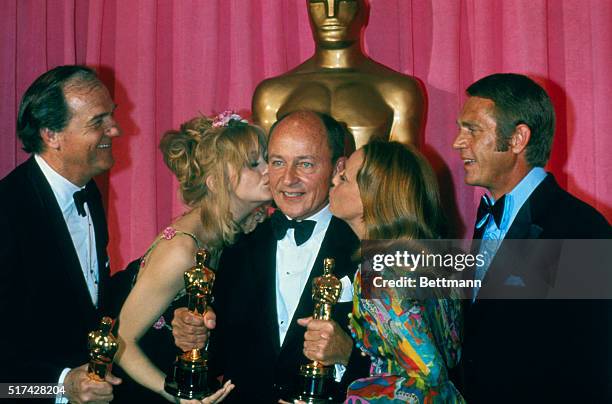Hollywood: Frank McCarthy, producer of the Best Picture, Patton gets kissed by actress Goldie Hawn and Jeanne Moreau after he won the top award and...