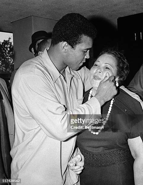 Former heavyweight champion Cassius Clay playfully pinches his mother after weigh-in here. Clay weighed in at 213-1/2 pounds, the second heaviest...