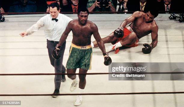 Joe Frazier is lead to a neutral corner by referee Arthur Mercante after the heavyweight champ sent Muhammad Ali to the canvas with a hard left in...