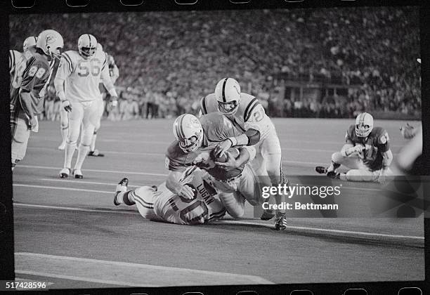 Miami running back Larry Csonka carries Colt safety Rick Volk on his back as he falls into the endzone for Miami's third touchdown in the AFC...