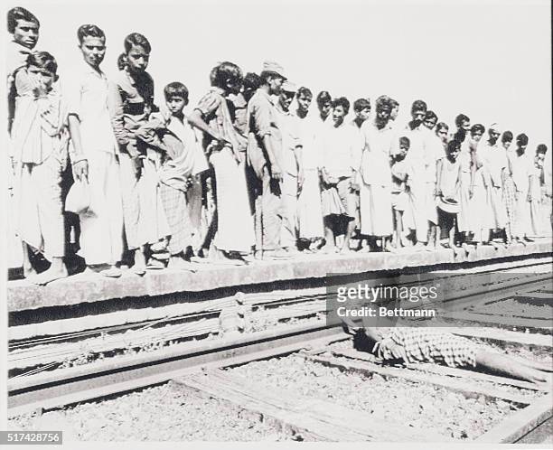 Jhikarghat, East Pakistan: Had Throat Slit. Local residents line up at a railroad stop to look at body of civilian with throat cut and stretched...