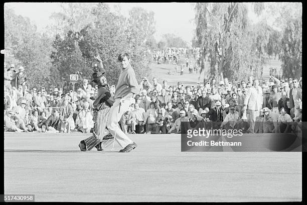 Los Angeles: Dave Hill of Evergreen, Colo., and his caddy start a happy dance around the 18th green an instant after Hill's 20 foot birdie dropped...