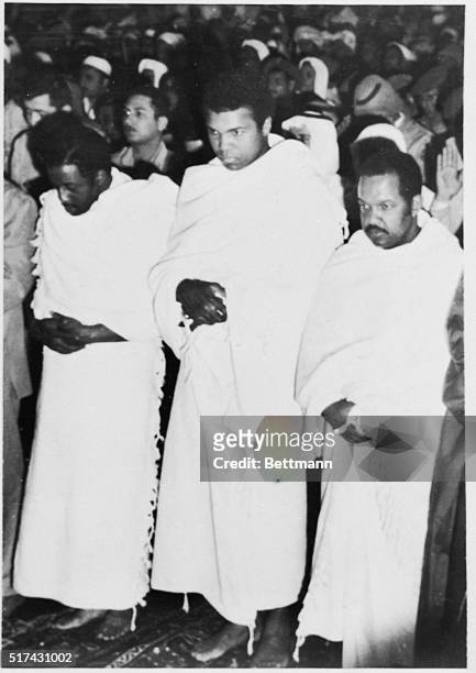 Flanked by fellow pilgrims, Muhammad Ali, former heavyweight champion of the world, prays inside the Holy Mosque in Mecca recently during his New...