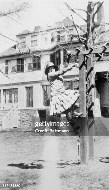 In this picture made around 1915, Anne Morrow climbs the arbor at her Englewood, New Jersey, home. The photo is from Bring Me a Unicorn: Diaries and...