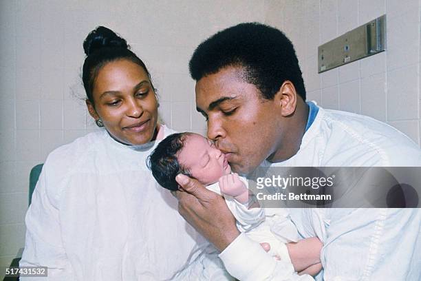 Former heavyweight champion Muhammad Ali kisses his newborn son, Muhammad Eban Ali, as his wife Belinda looks on in the Women's Medical Hospital. The...