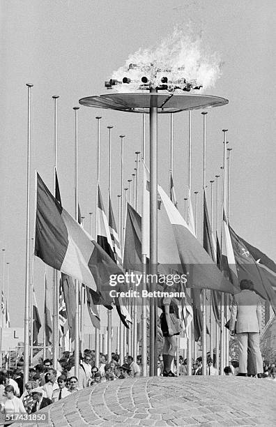 Flags of nations are at half-staff behind the Olympic torch during memorial services September 6 for the 11 dead Israeli athletes.