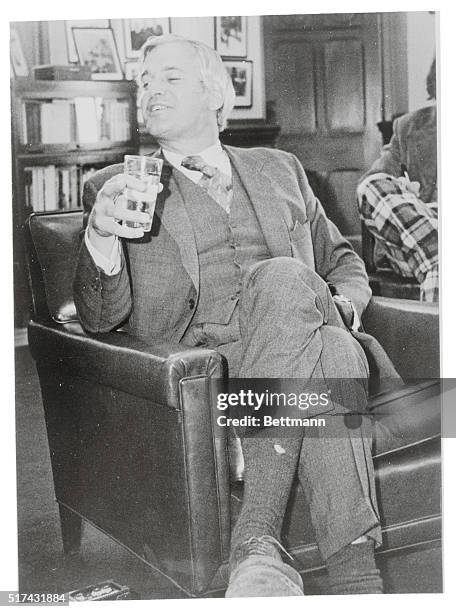 Finance Minister John Turner, sits relaxed with a glass of water in his hand and a hole in his sock during an early morning briefing in his office...