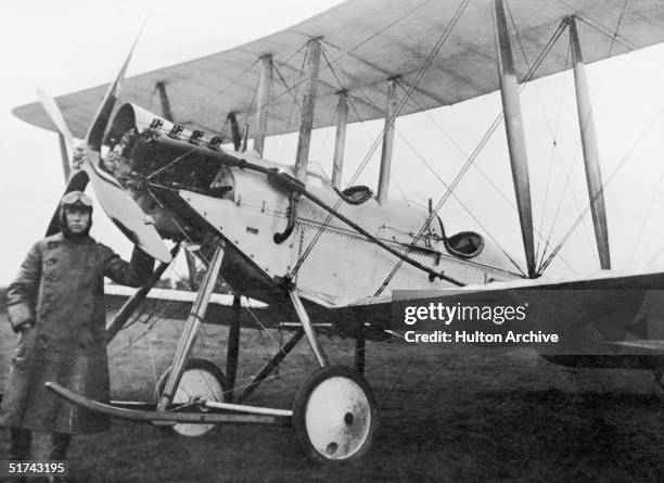 Pilot stands next to his De Havilland BE2 which was used as an early bomb carrier, 1914. A small number of bombs would be released from the plane by...