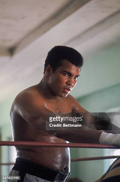 World heavyweight champion Muhammad Ali, his face still unmarked, is a bit paunchy around the midsection, however. He's taking a breather during a...
