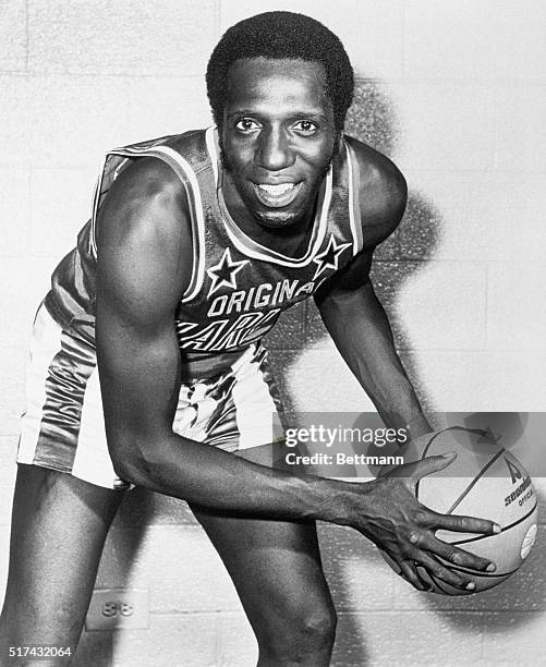Photograph of Lemon Meadowlark of the Harlem Globetrotters. Photo shows Meadowlark with basketball in an action pose in front of a brick wall....