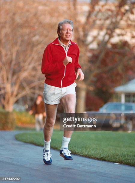 Washington: President Carter is shown jogging on the South Lawn of the White House. The President's sweat shirt is red and shorts are white.