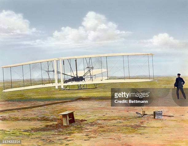 Wilbur Wright watches Orville Wright pilot the first successful heavier-than-air flight in the Wright Flyer at Kitty Hawk, North Carolina on December...