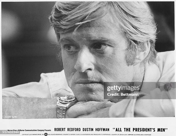 Close-up of Robert Redford leaning his chin on crossed arms in a movie still from All the President's Men. The film starred Redford as Bob Woodward...
