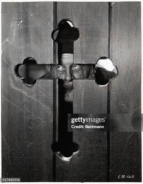 Emil Jannings peers through a cross-shaped opening in a door in a movie still from "The Way of All Flesh." Jannings won the Academy Award for Best...