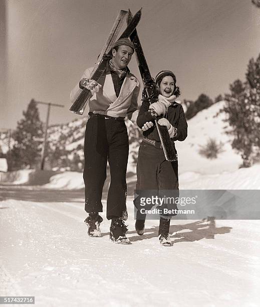 Ankling along the snow-covered slopes of the Big Pines mountain resort in California, in search of spot to try out their skills, are John Wayne,...