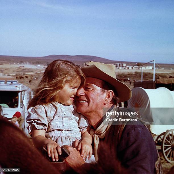 John Wayne hugs his daughter, Aissa, on the set of The Alamo at the "Happy" Shahan Ranch. | Location: Near Brackettville, Texas, USA.