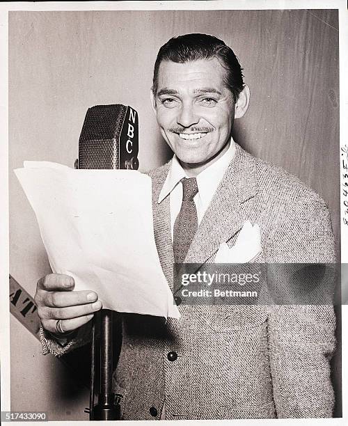Waist-up portrait of actor Clark Gable as he reads into a NBC radio microphone. Filed: 12/1946.