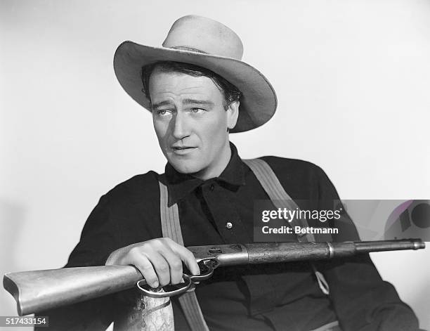 John Wayne holding a rifle in a publicity photo for the movie Shepherd of the Hills.