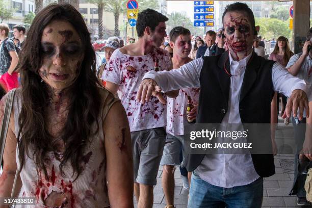 Israelis wearing costumes take part in a "Zombie walk" in the city of Tel Aviv as part of the Jewish holiday of Purim on March 25, 2016. The...