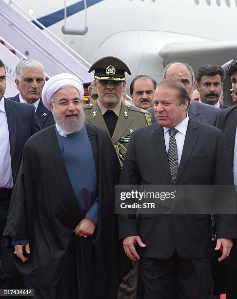 Pakistan's Prime Minister Nawaz Sharifspeaks with Iranian President Hassan Rouhani upon his arrival at the military base in Rawalpindi on March 25,...