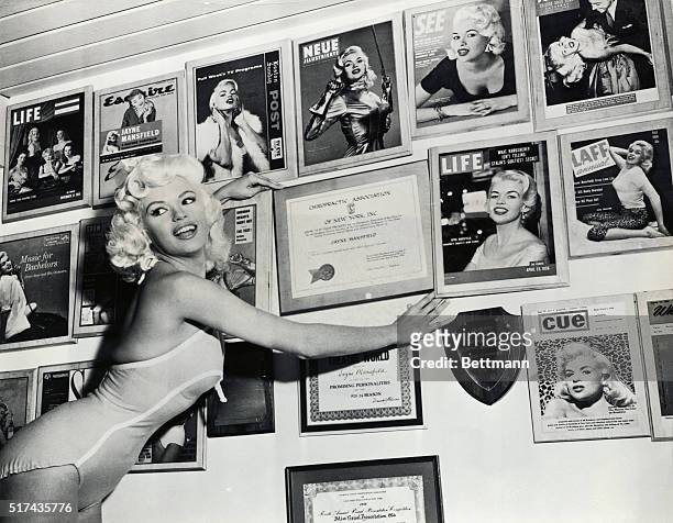 Jayne Mansfield, Hollywood screen siren is shown here surrounded by magazines covers which bare her image.