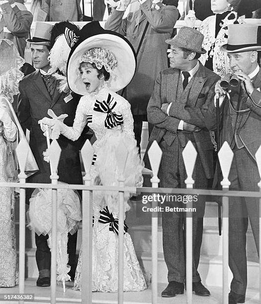 Eliza Doolittle , accompanied by Freddie Eynsford-Hill , Professor Henry Higgins , and Colonel Hugh Pickering , gets excited at the Ascot Races in My...