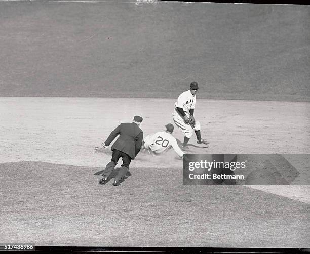 Pie Trynor of the Pittsburgh Pirates, slides safely into second base as Travis Jackson of the New York Giants takes the throw. Umpire Quigley calls...