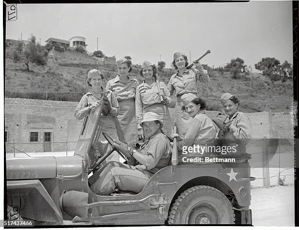 Their softball practice over for the day, these WACs stationed in North Africa, climb aboard a jeep for a ride back to barracks, some of them bound...