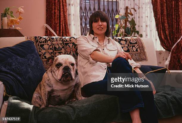 American singer-songwriter and guitarist Chrissie Hynde, of rock group The Pretenders, at home with her dog, UK, 1999.